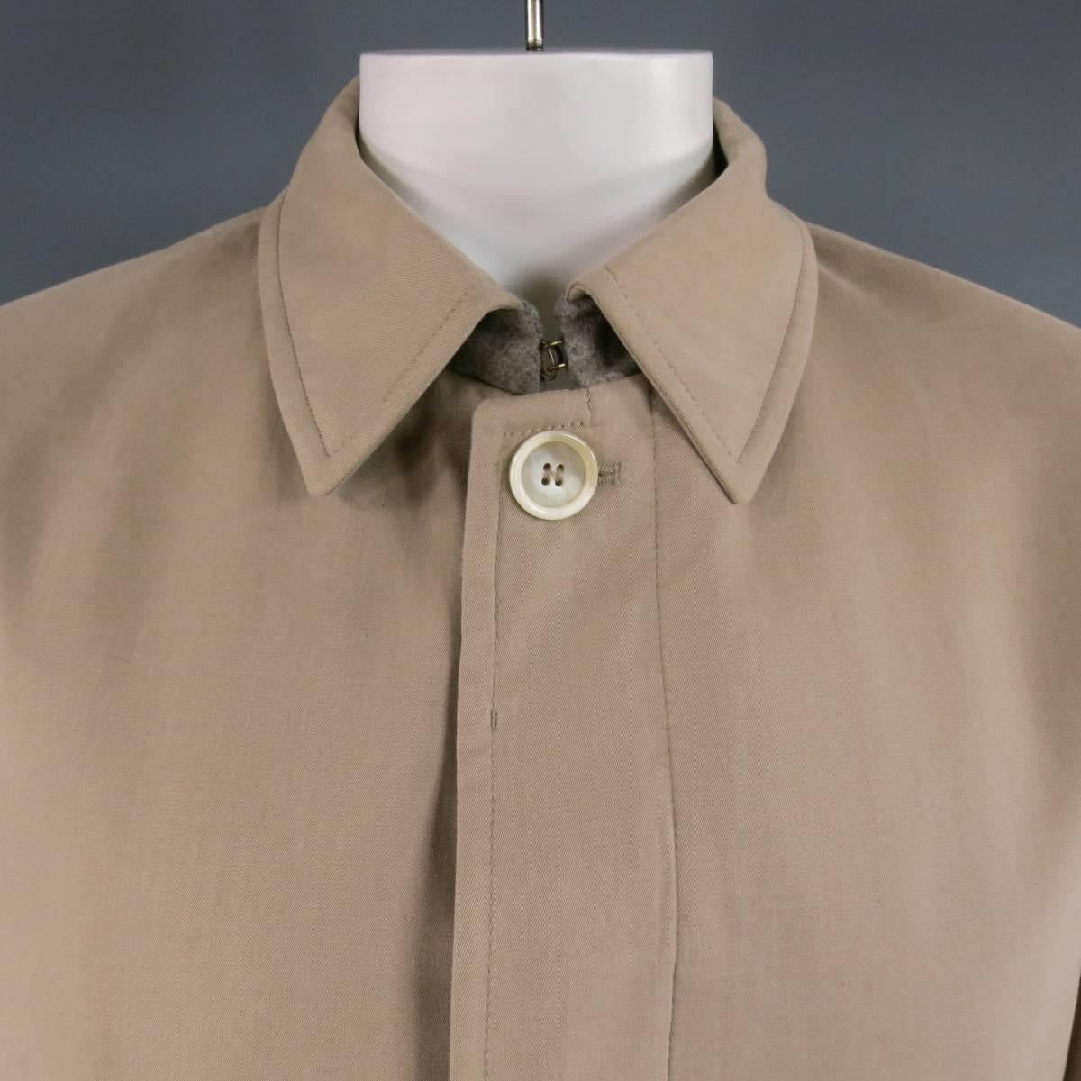 This classic BRUNELLO CUCINELLI light weight coat comes in a light brown beige cotton cashmere blend and features a pointed collar with Heather gray lining, button up and zip closure with hidden placket, vertical pockets, and flap pockets. Made in