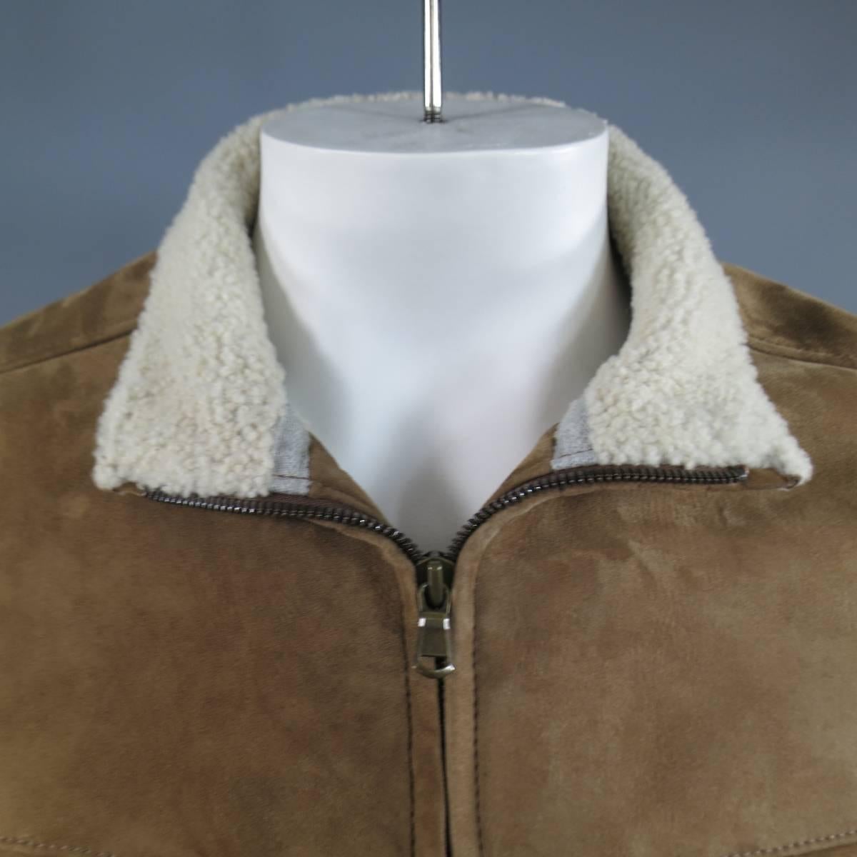 Classic BRUNELLO CUCINELLI jacket comes in a light beige taupe tan suede shearling and features a high neck, zip up closure, double zip breast pockets, and slit pockets on front. Made in Italy.

Reatails at $5,800.00.

Excellent Pre-Owned