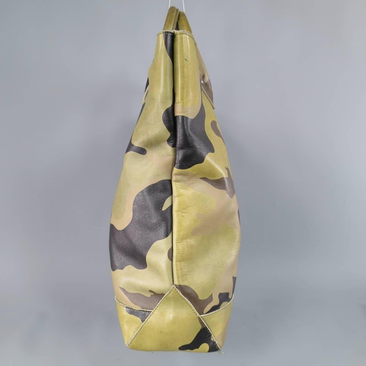 eYe JUNYA WATANABE / COMME des GARCONS for VANSON LEATHER Tote Bag consists of 100% leather material in a olive color tone. Designed with top handles, silver stud detail and tone-on-tone stitching. Camouflage print patterns throughout body with grey