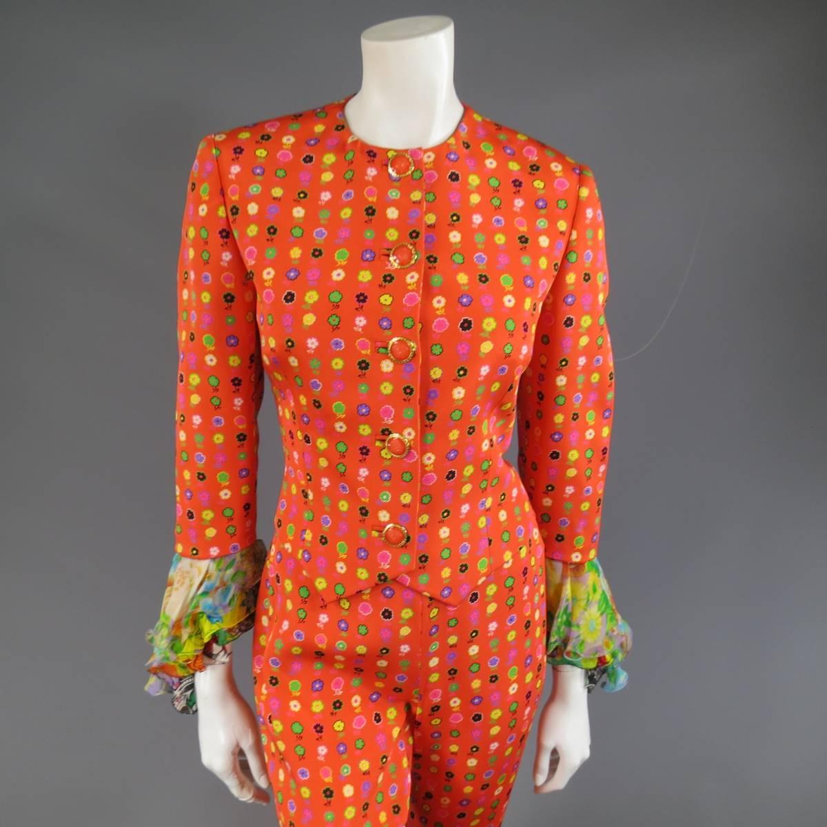 This fabulous GIANNI VERSACE COUTURE pants suit comes in a vibrant orange silk with an all over digital multi color floral print and features jacket with a round crew neckline, orange enamel Medusa buttons with gold tone metal frame, double point