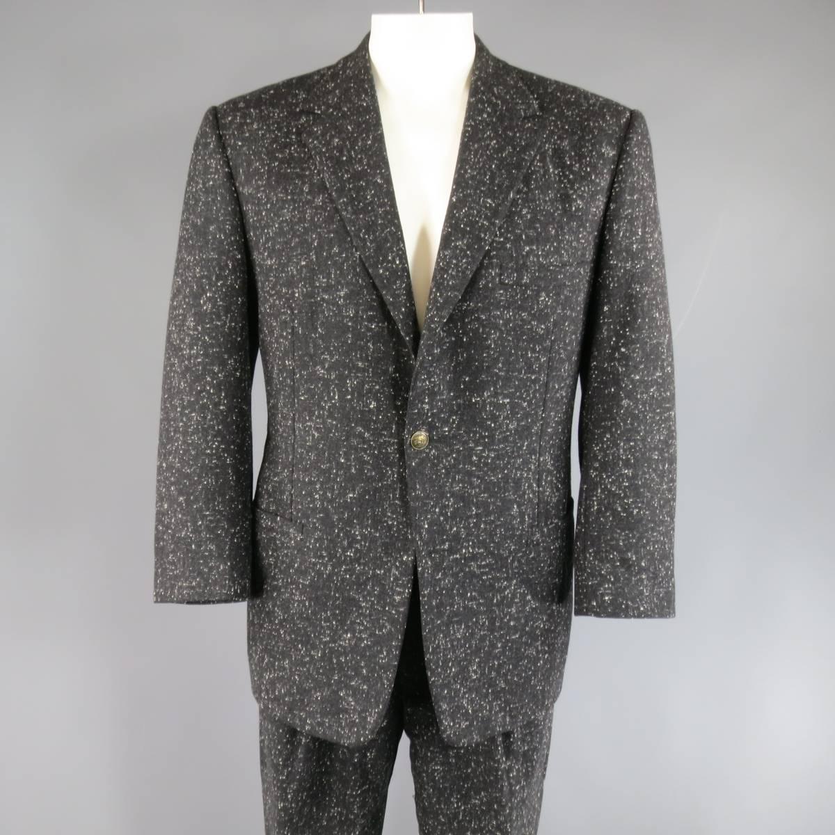 Chic vintage GIANNI VERSACE fall/winter suit comes in a charcoal heather wool with cream spots throughout and includes a three button sport coat with notch lapel, double slit pockets, and dark gold brass Medusa buttons and matching pleated trousers.