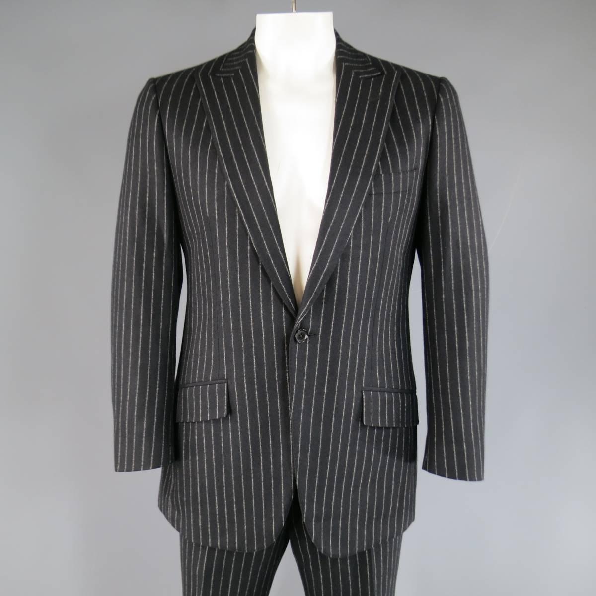 Contemporary tailored VALENTINO suit in black and light gray chalkstripe pinstripe wool includes a peak lapel single button sport coat with slanted pockets and double vented back and matching flat front dress pants. Made in Italy.
 
Excellent