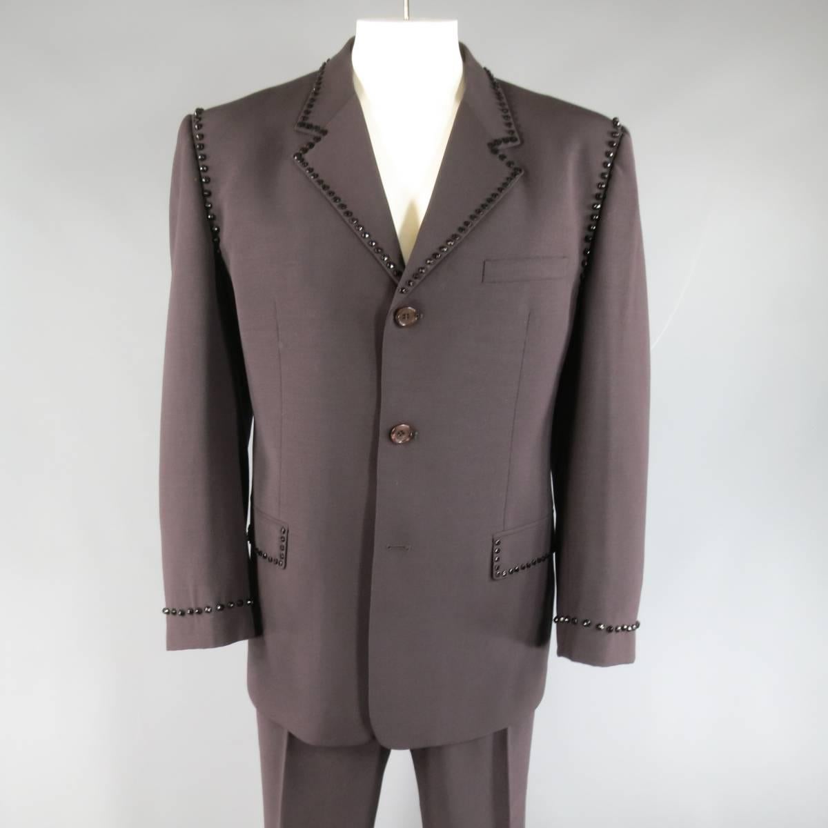 This rare vintage GIANNI VERSACE (Red Label) suit comes in a light weight muted eggplant taupe color wool and includes an oversized three button sport coat with a notch lapel, double flap pockets, single vented back, and black crystal like beaded