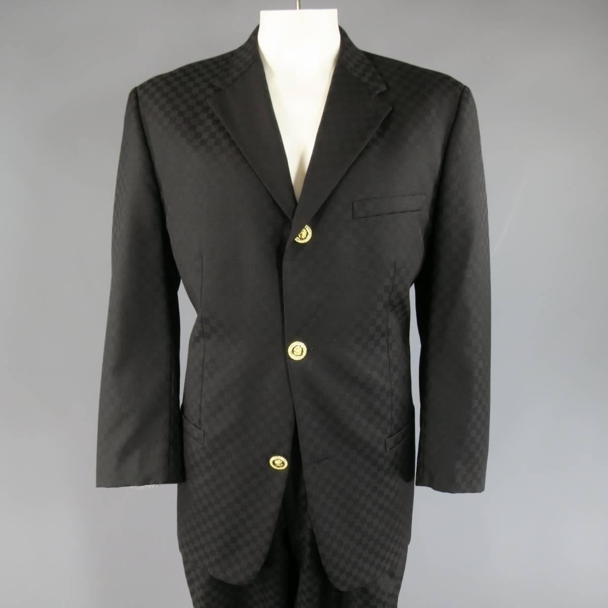 Vintage GIANNI VERSACE suit in black on black checkered wool includes a three button, notch lapel sport coat with gold & black enamel. rhinestone studded lion head buttons and matching pleated trouser with cuffed hem. Made in Italy.
 
Excellent