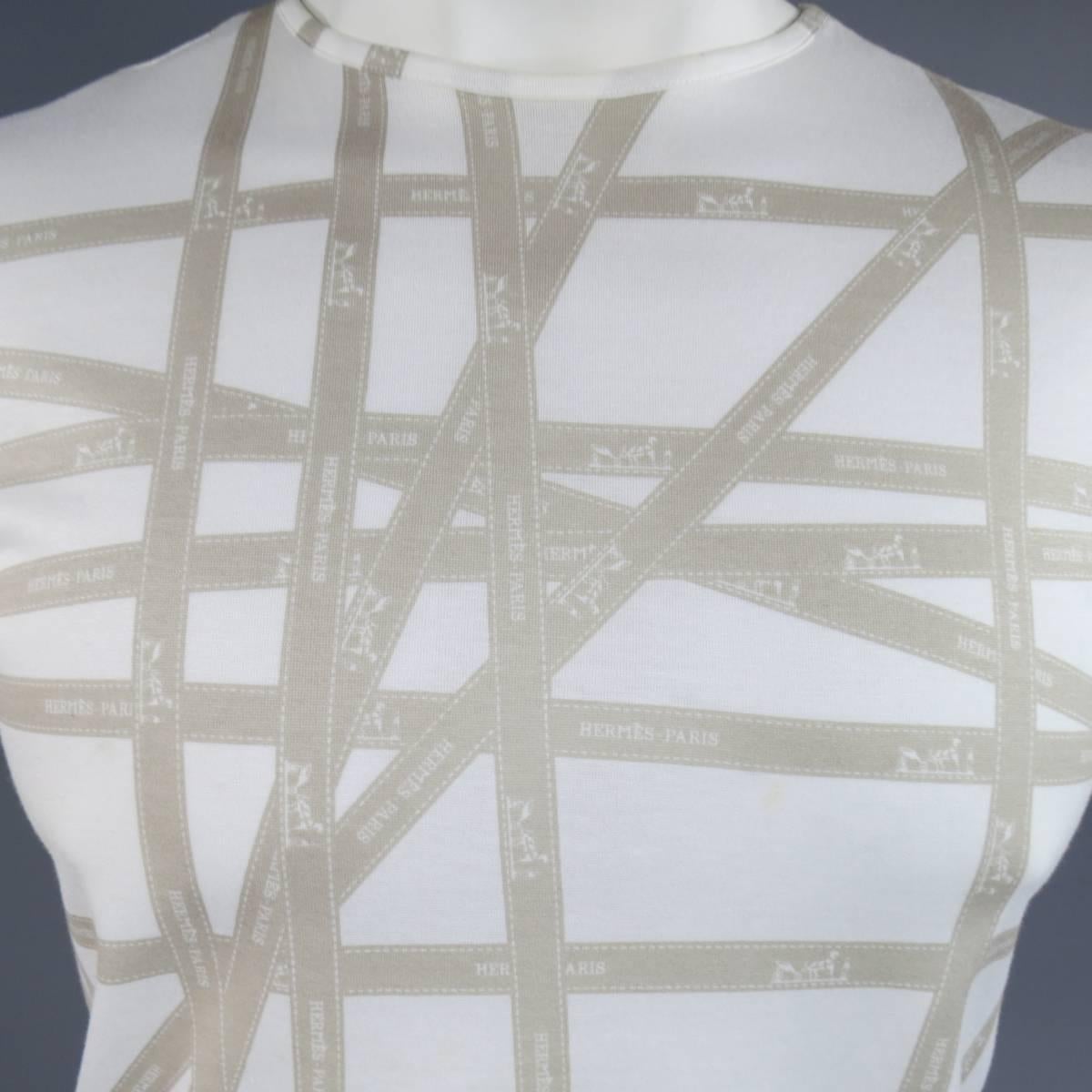 Vintage HERMES tee shirt in a light weight, semi sheer, white cotton with a crewneck, short sleeves, and all over taupe beige Hermes Bolduc ribbon print. Small stain shown in detail shot. Made in Italy.
 
Good Pre-Owned Condition.
Marked: XL
