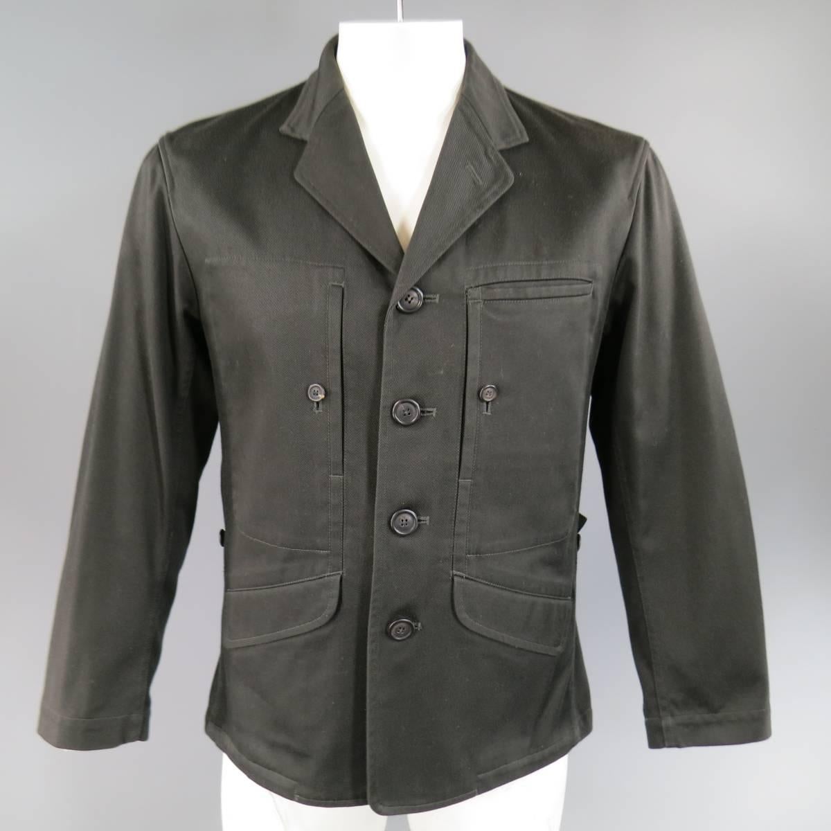 This rare vintage ISSEY MIYAKE MAN jacket comes in an olive charcoal cotton twill and features a notch lapel, four button closure, double slanted flap pockets, vertical button slip patch pockets on the chest, elastic drawstring hem, and back tabs.