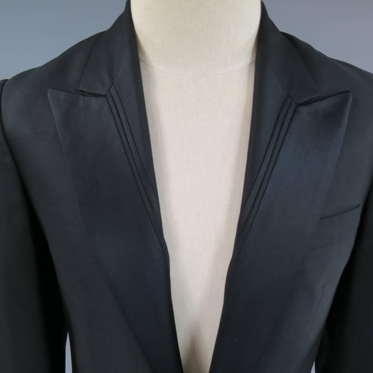 This ultra chic VIKTOR & ROLF tuxedo dinner jacket comes in a shiny wool silk blend material with a sleek single button closure, satin peak lapel with stripe detail, double flap pockets with top stitching, functional button cuff sleeves, and single