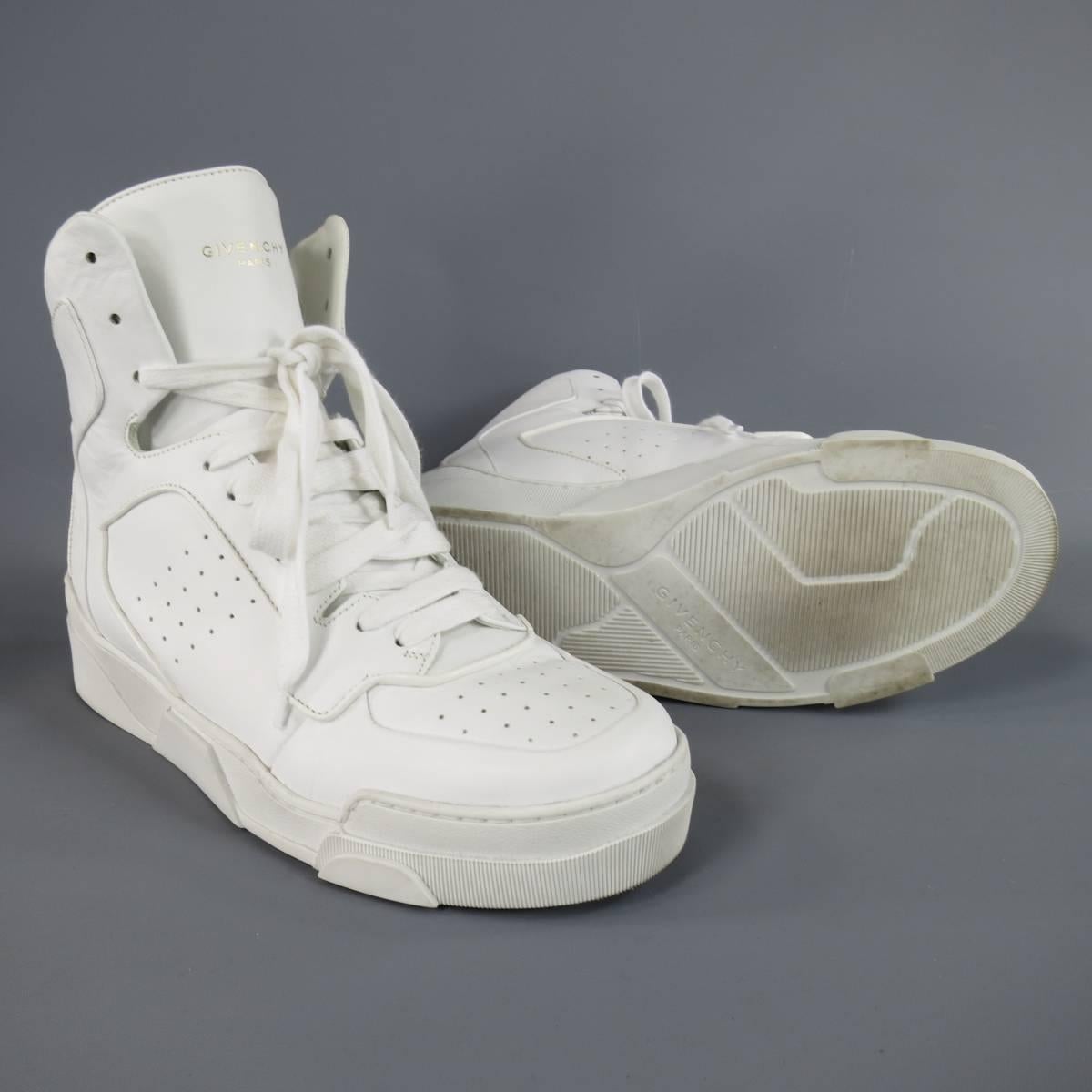 GIVENCHY "TYSON II" high top sneakers come in a smooth white leather in an Air Force 1 inspired design with a perforated toe box, structural midsole, high tongue with gold flake logo, and ribbed back with tab. Minor wear. Made in