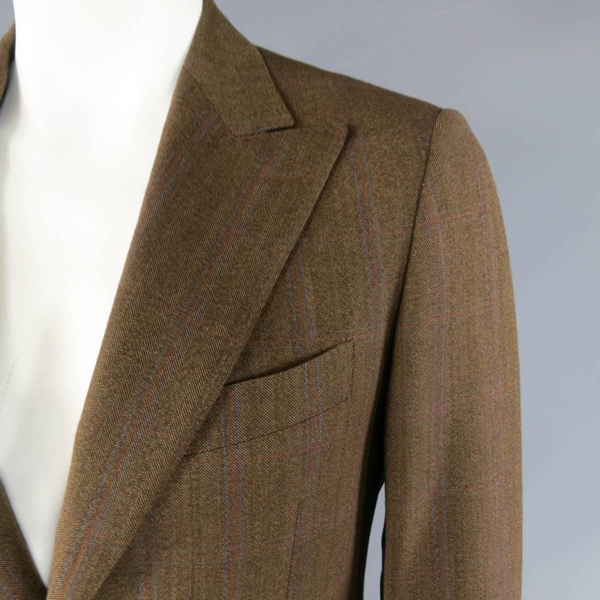 Classic PAL ZILERI two button sport coat in a light brown harringbone textured wool with all over blue and red windowpane print. Detailed with a top stitch peak lapel, flap pockets, functional button cuffs, and double vented back. Made in Italy.
