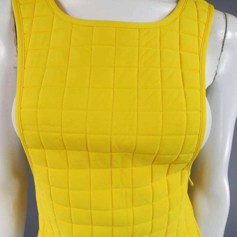 Fabulous CHANEL Spring 2000 runway vest in a goldrod yellow quilted neoprene like material with a side zip closure and silver tone metal CC emblem. Cut narrow to be worn as a layering piece. Some wrinkling throughout. Can be pressed by a