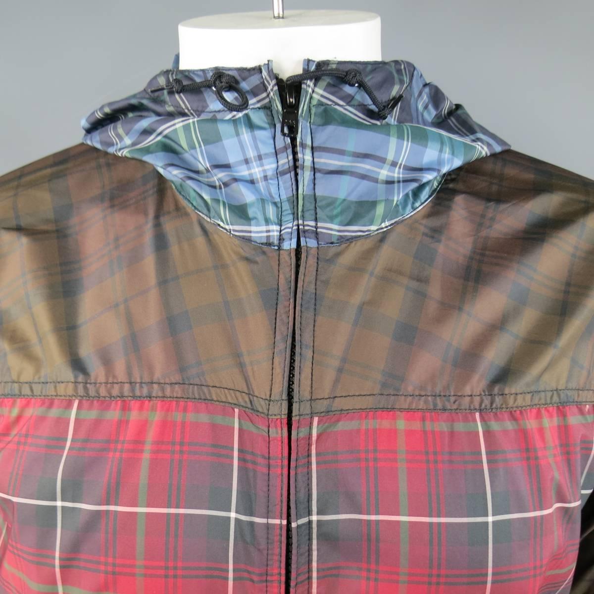 This unique COMME DES GARCONS SHIRT windbreaker comes in a light weight, mixed, color block red, brown, and blue plaid and features a double zip front, drawstring waist, grommet vented under arms, and back zip pocket.
 
Excellent Pre-Owned