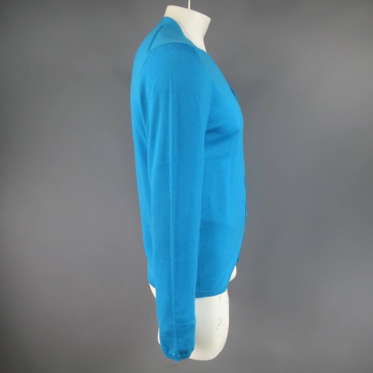 Classic V neck cardigan by Comme des Garçons Shirt in a light weight aqua blue soft wool knit. Made in Italy.
 
Excellent Pre-Owned Condition.
Marked: L
 
Measurements:
 
Shoulder: 19 in.
Chest: 44 in.
Sleeve: 28 in.
Length: 27 in.