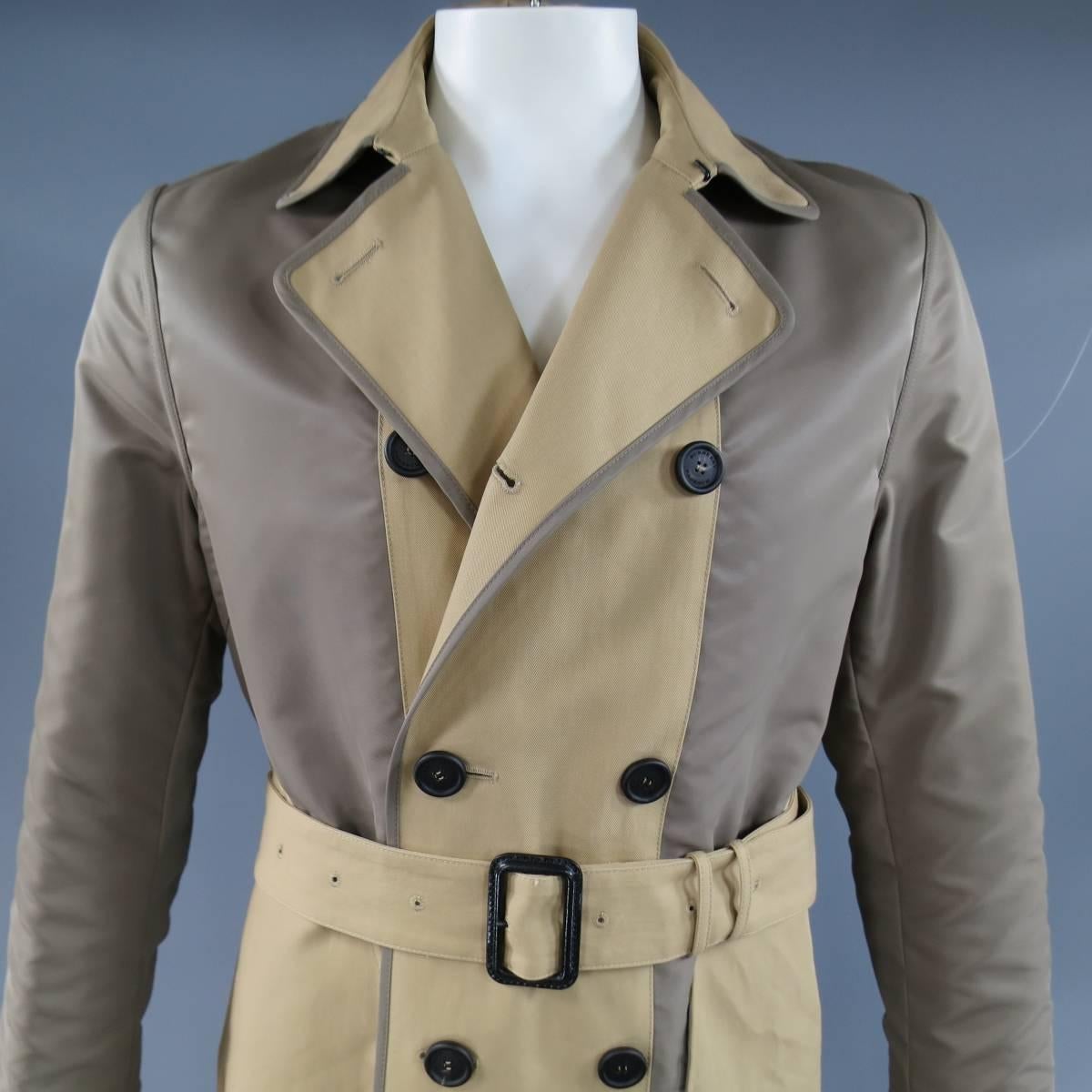 Modern double breasted trench coat by BURBERRY PRORSUM comes in a two tone, color block, classic tan khaki coated cotton twill with taupe nylon panels and can be worn inside out as a classic solid beige trench with taupe piping. Made in