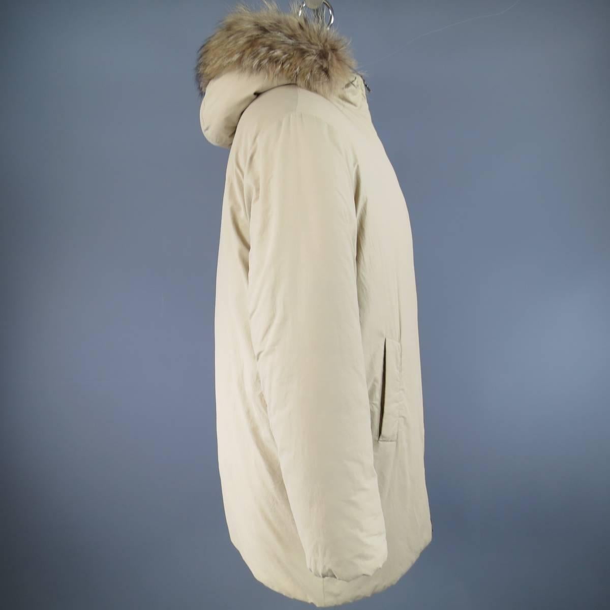 Winter PRADA parka in a warm khaki padded cotton blend featuring a high neck double zip closure, double slanted pockets, and racoon fur trimmed hood. Made in Italy.
 
Good Pre-Owned Condition.
Marked: M
 
Measurements:
 
Shoulder: 21