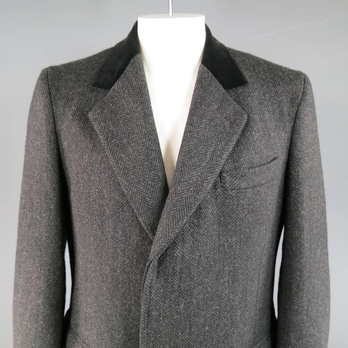 Classic winter coat by BARNEY'S NEW  YORK in a charcoal gray Herringbone print heavy wool featuring a notch lapel, black velvet collar, hidden placket button up closure, double flap pockets, and single vented back. Made in USA.
 
Excellent