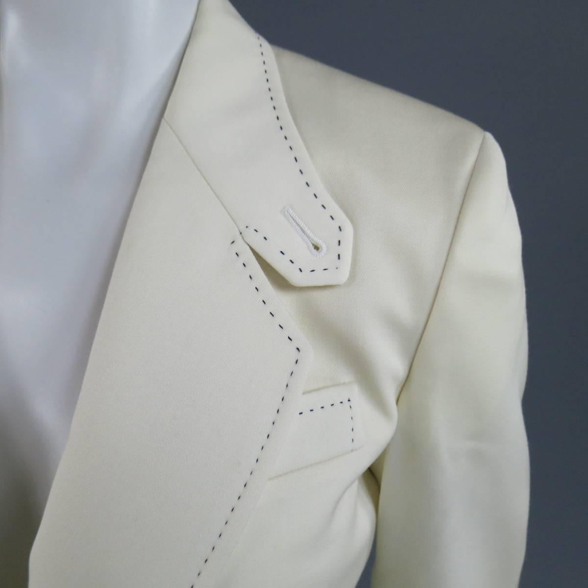 This chic CHLOE riding jacket comes in a rich cream wool twill and features a classic notch lapel with button tab, double slanted single button closure, and black contrast stitching throughout. Faint mark shown in detail shot. Made in Italy.
