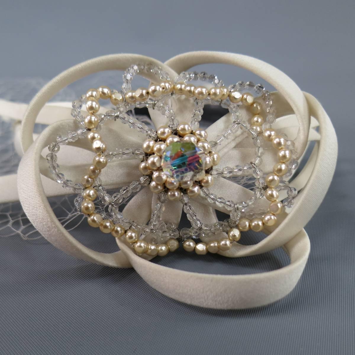 Lovely ALEXANDRE de PARIS headband in a cream silk satin with a deaded flower with satin straps and mesh vale with spots. Wear throughout. As-Is. Made in Italy.
 
Good Pre-Owned Condition.