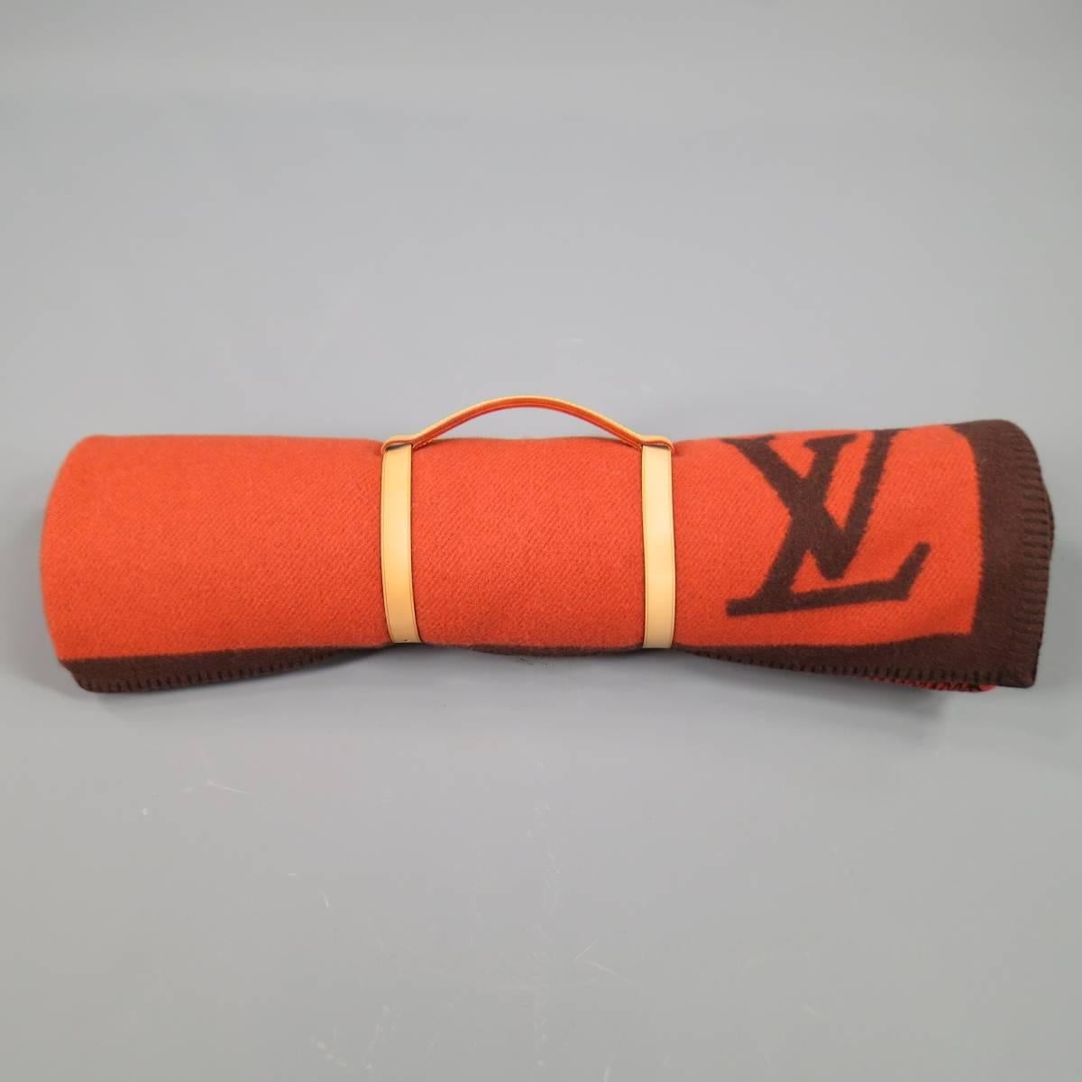 LOUIS VUITTON Karakoram Blanket scarf in a soft structured bold orange thick wool cashmere blend fabric with brown print throughout and embossed vachetta leather harness. Minor wear on harness. Made in Scotland
 
Excellent Pre-Owned Condition.
 
68