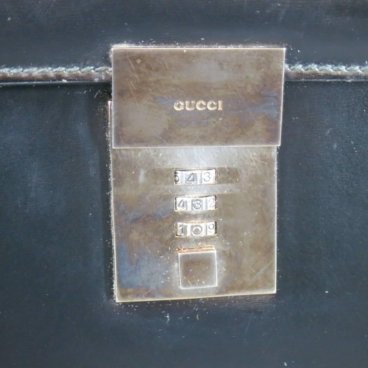 Vintage GUCCI briefcase in a shiny black leather featuring a flap top with silver tone metal combination closure, top handle and triple compartment storage. Wear throughout leather and tarnishing on hardwear. As-Is. Made in Italy.
 
Fair Pre-Owned