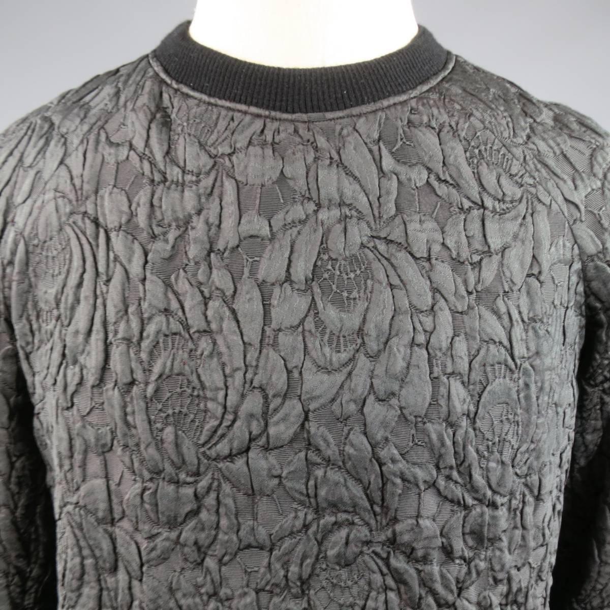 This unique unisex DRIES VAN NOTEN pullover comes in a deep green floral lace brocade with burgundy iridescence and features a ribbed black crewneck, raglan sleeves, and black under layer with red and gold print. Small imperfection on back. Made in