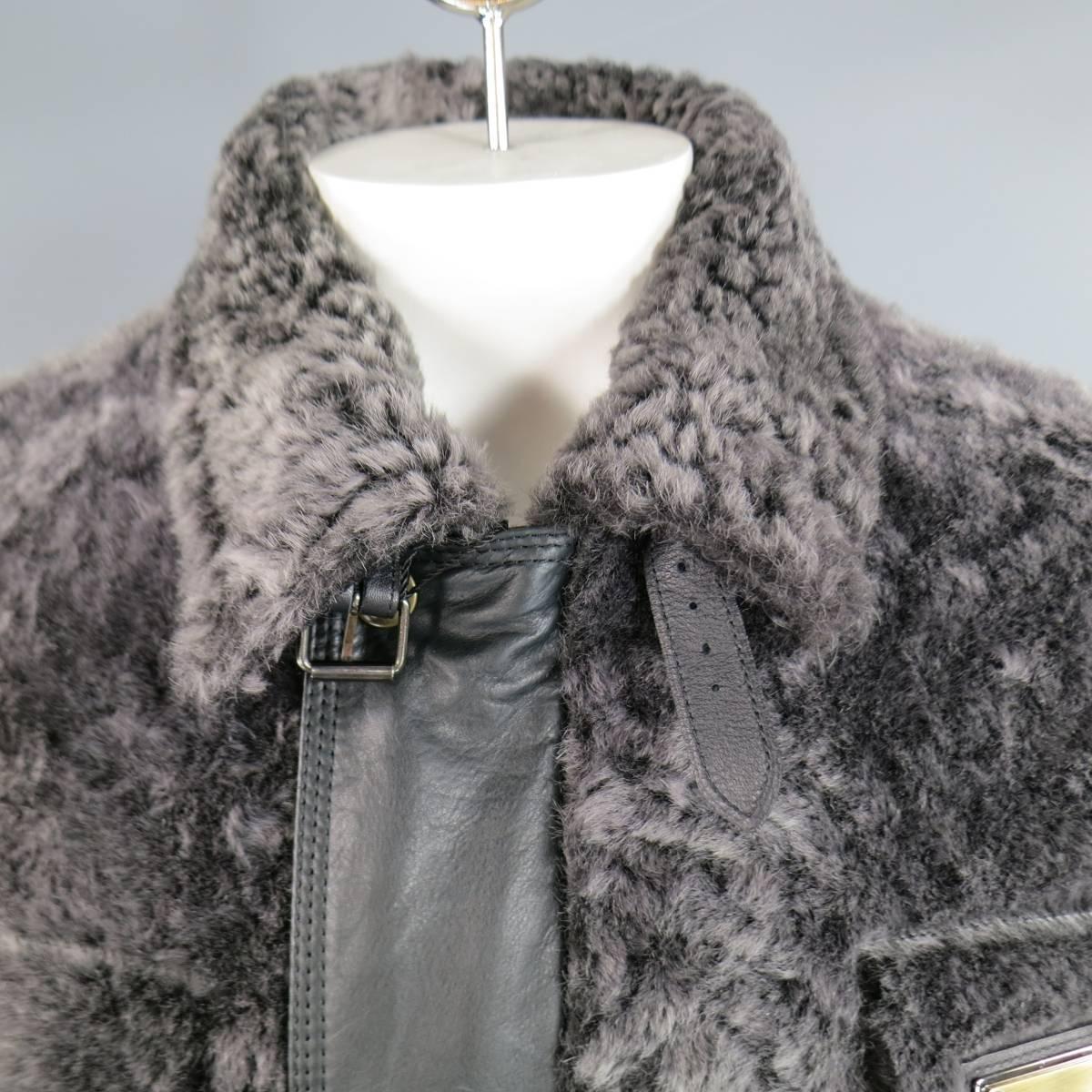DOLCE & GABBANA winter jacket in a black and charcoal plaid wool featuring gray lambskin fur panels, pointed collar with belt, gold tone engraved plaque on chest, slit pockets, hidden leather placket zip closure, and side belts. Made in Italy.
