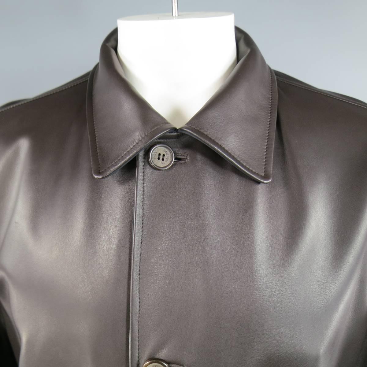 Classic winter coat by ERMENEGILDO ZEGNA in a rich brown leather featuring a pointed collar, button up closure, patch pockets, and reversible black windbreaker lining. Minor wear on leather and missing top button on nylon side. Made in Italy.
