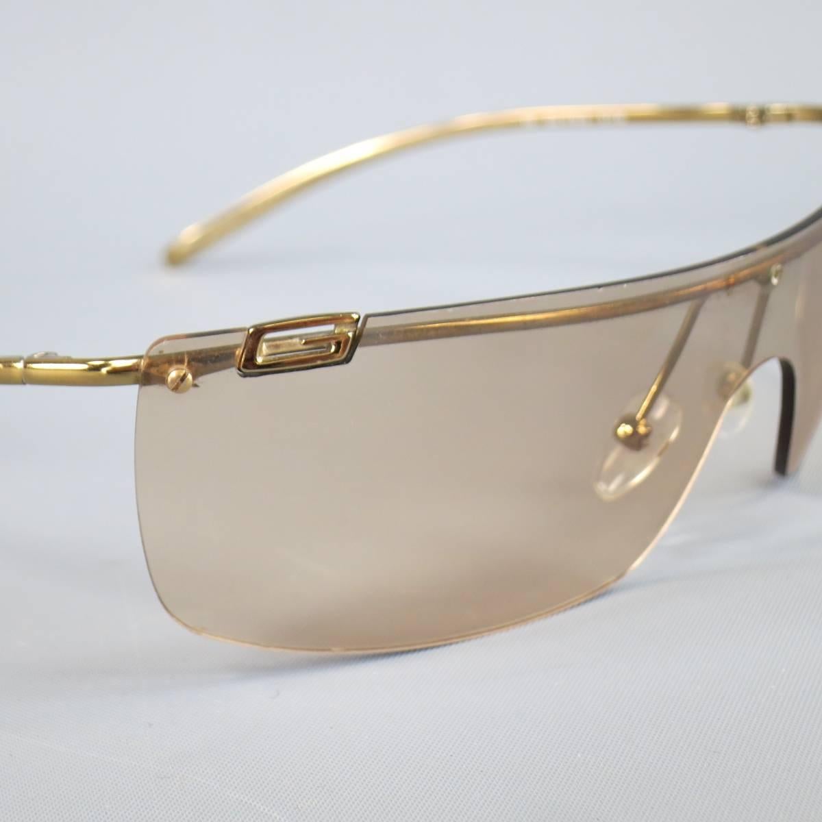 These retro inspired GUCCI sunglasses feature an angular rose gold gradient shield lens with skinny gold  arms and G logo. Minor Scratches on lens. As-Is. Made in Italy.
 
Fair Pre-Owned Condition.
Marked: 115 GG 17/19/S 57716
 
99 mm x 3 mm x 115 mm