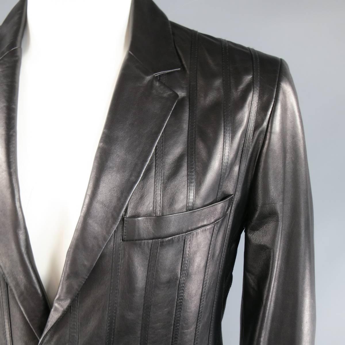 VERSUS by VERSACE sport coat in a soft black leather featuring a slim notch lapel, two button closure, flap pockets, button cuffs, and leather pinstripe applique's along the front. Made in Italy.
 
Excellent Pre-Owned Condition.
Marked: 40/54
