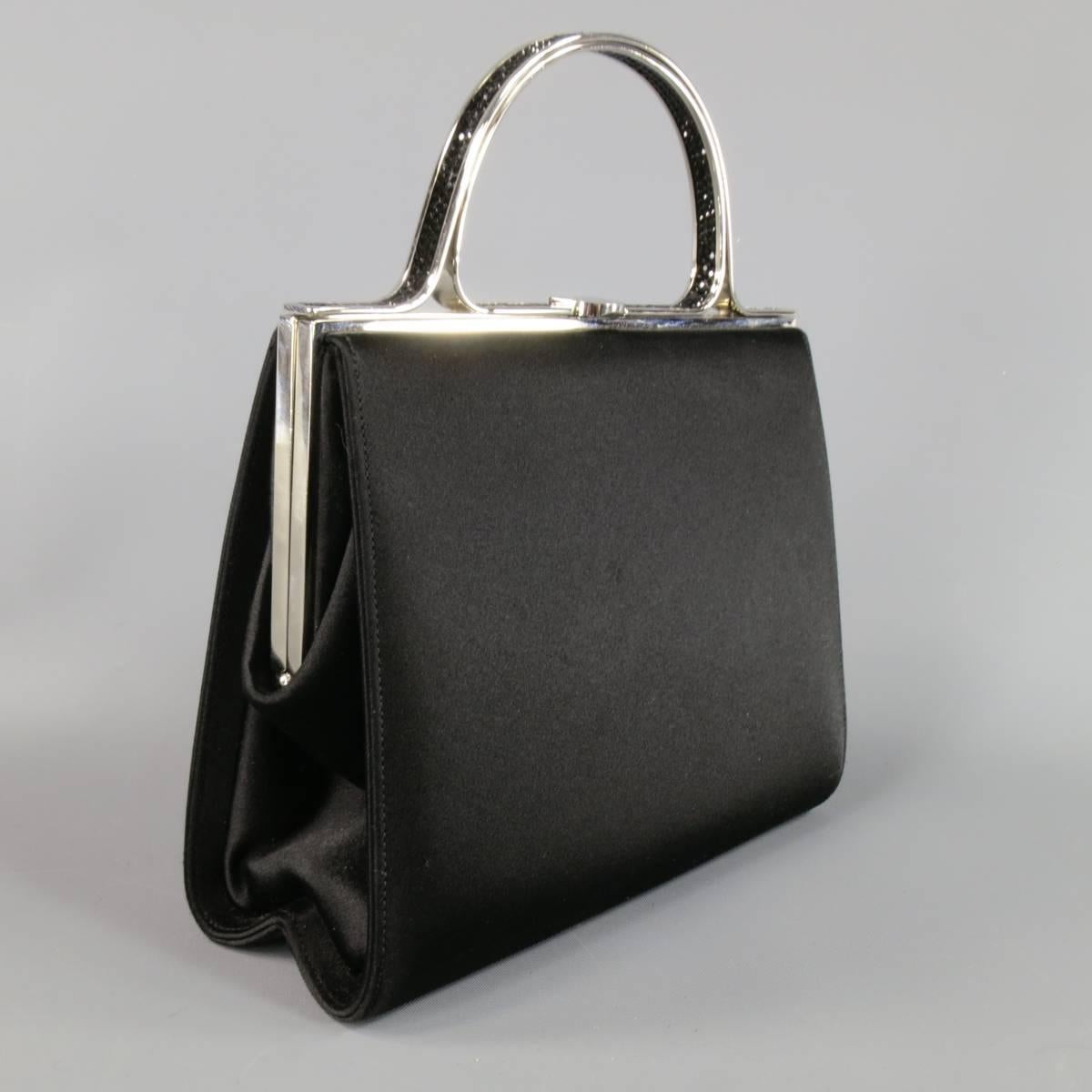 Vintage JUDITH LEIBER evening bag in black silk satin featuring a silver tone metal handle with black crystal embellishments. Includes dust bag, mirror, and comb with tassel. Missing one stone shown in detail shot. Made in Italy.
Retails at