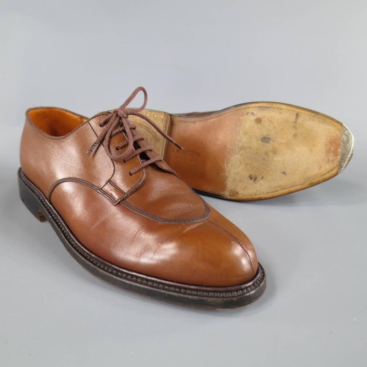 J.M. WESTON Lace-Up Shoes consists of leather material in a tan color tone. Designed in a derby style, front toe seam with top fine stitching along sides. Detailed with a metal toe base, dark brown leather sole. Comes with original box. Hand made in