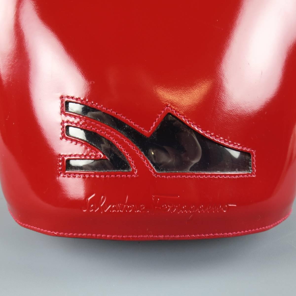 Rare vintage SALVATORE FERRAGAMO backpack in red structured atent leather featuring a drawstring bucked shape, clear vinyl logo front with embossed logo, clear vinyl top handle, skinny shoulder straps with gold tone Gancini buckles, and internal