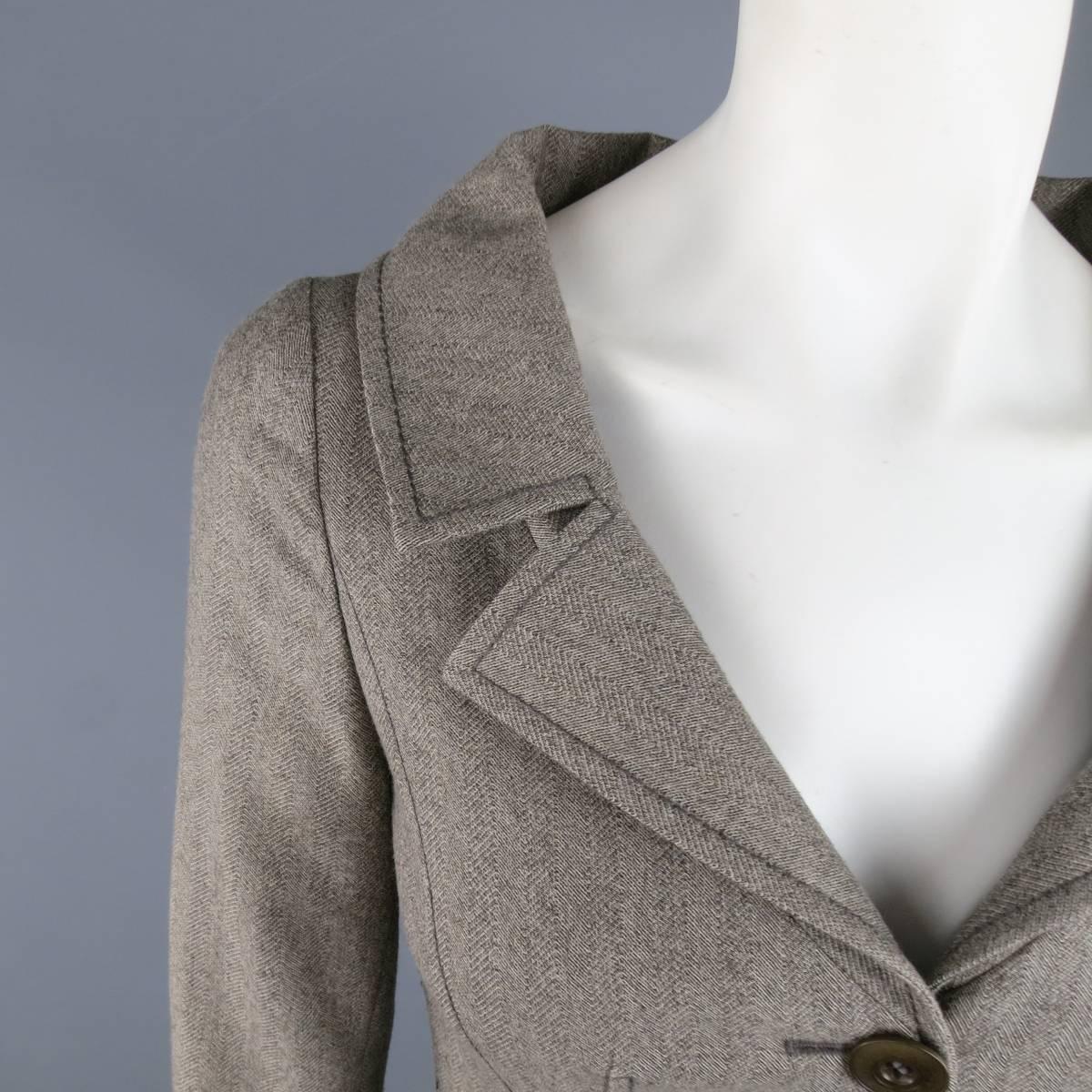 Cropped blazer by VALENTINO in a gray and taupe Herringbone print fabric featuring a wide lapel collar, two button closure, and slit cuffs. Made in Italy.
 
Excellent Pre-Owned Condition.
Marked: 40 / 4
 
Measurements:
 
Shoulder: 14 in.
Bust: 32