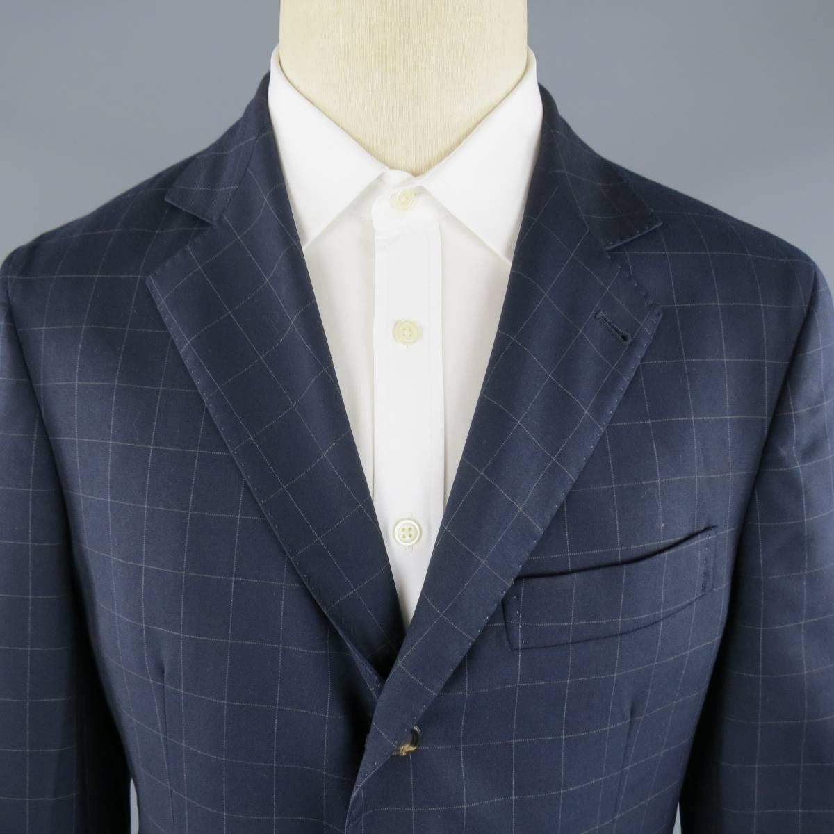 BRUNELLO CUCINELLI Sport Coat consists of wool material in navy color tone. Designed in a 3 button front, notch lapel collar with 4 button cuffs. Detailed with top pocket square and bottom flap pockets. Checkered pattern with suede elbow patches.