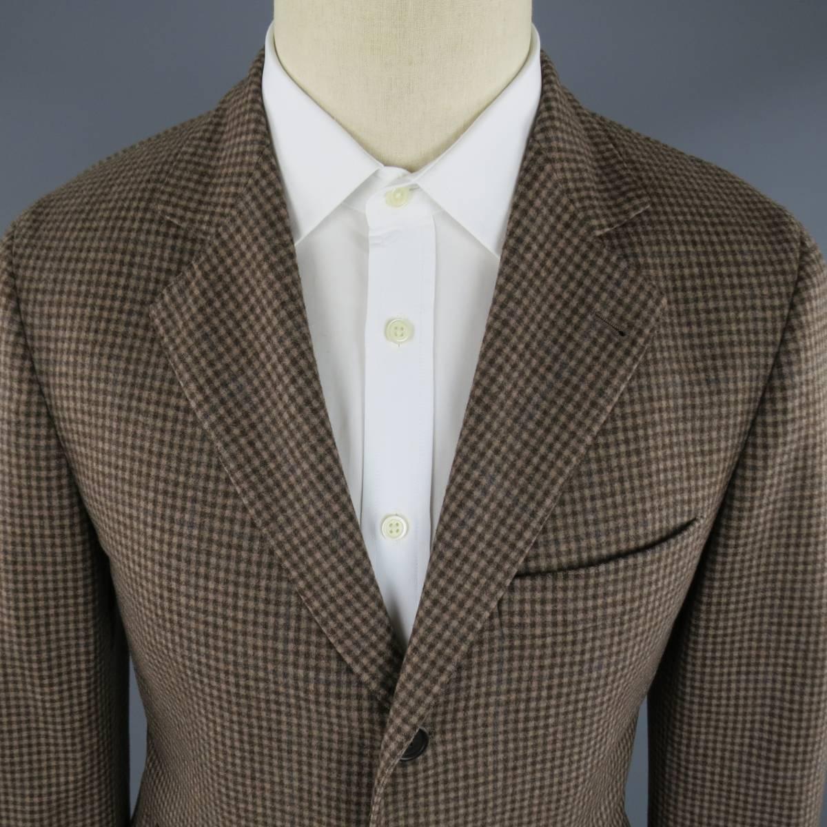 BRUNELLO CUCINELLI Sport Coat consists of wool material in a tan color tone. Designed in a 3 button front, notch lapel collar with 4 button cuff sleeves. Detailed checkered pattern, top pocket square and bottom flap pockets. Double back vent and