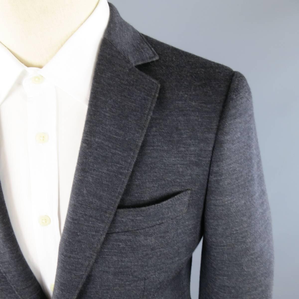 BRAND NEW SALVATORE FERRAGAMO Sport Coat consists of wool blend material in a charcoal color tone. Designed in a 2 button front, notch lapel collar and 4 button cuff sleeves. Detailed with top pocket square, bottom flap pockets and single back vent.