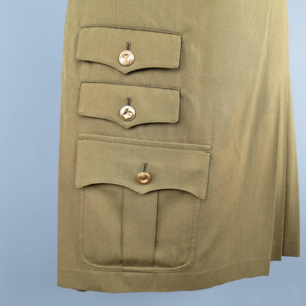 COMME des GARCONS Spring/Summer 2015 collection kilt shorts in a light olive green wool twill featuring a half pleated skirt with leather buckle tab closure, frontal military pockets with crushed gold brass buttons, and classic Bermuda short back.