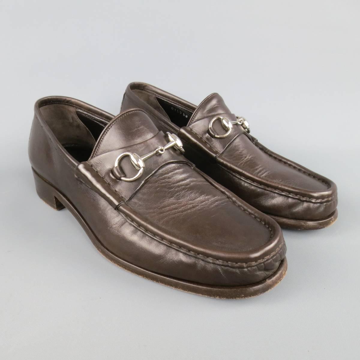 Classic GUCCI loafers in a rich chocolate brown smooth leather featuring a top stitch toe, silver tone brass horsebit detail and monochromatic sole. Made in Italy.
 
Excellent Pre-Owned Condition.
Marked: 8.5
 
Outsole: 11 x 3.75 in.