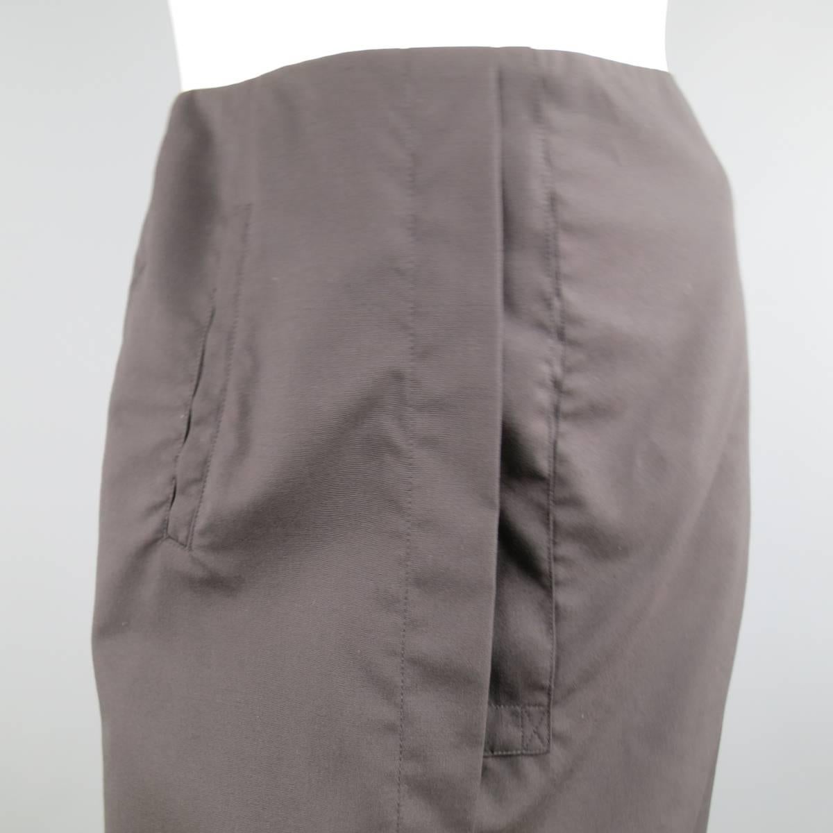 DROZDZIK pencil skirt in a black wool/gabardine features asymmetrical front pleating with pocket on right side, and sheer ruffled chiffon fishtail with bow. Made in USA.
 
New with Tags. Retails at $499.00.
Marked: 6
 
Measurements
Waste: 30