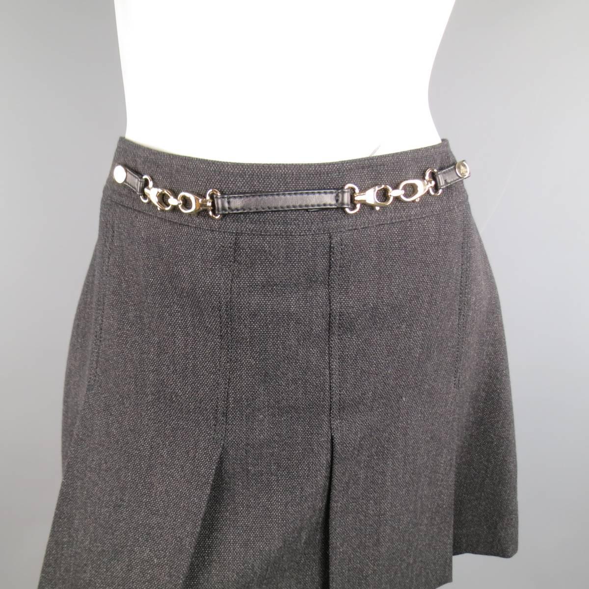 GUCCI mini skirt in a charcoal and black wool tweed featuring large box pleats and gold tone metal hardware belt detail with black leather strap. Made in Italy.
 
Excellent Pre-Owned Condition.
Marked: IT 44
 
Measurements:
 
Waste: 31 in.
Hips: 40