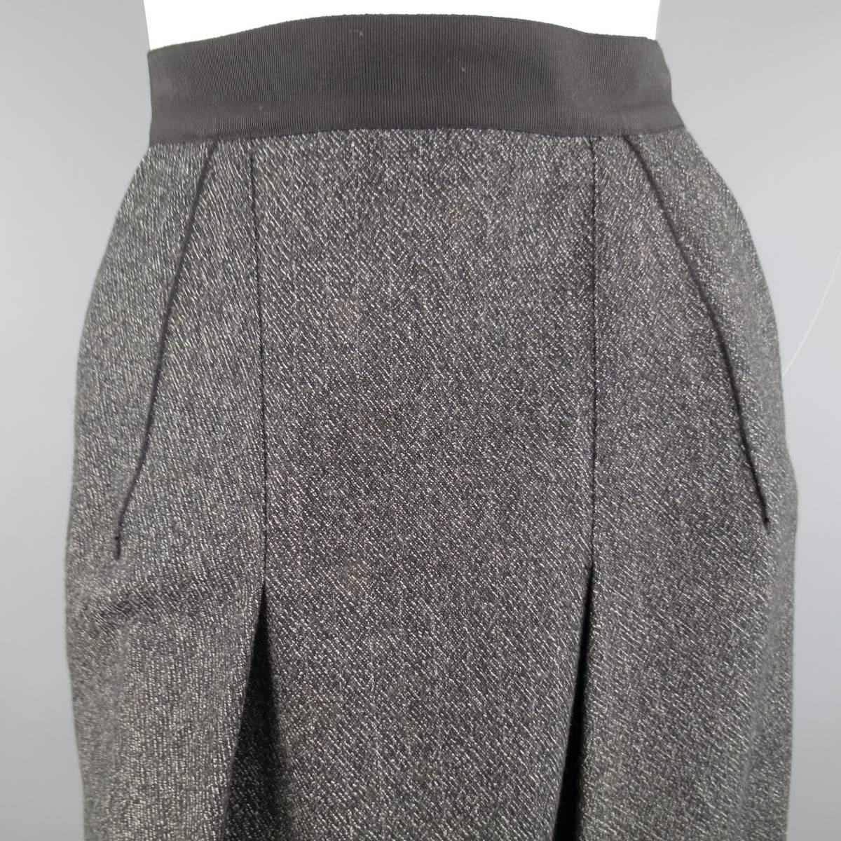 DOLCE & GABBANA A-line skirt in a heather textured fabric featuring a darted front with pleats and thick ribbon waistband. Made in Italy.
 
Excellent Pre-Owned Condition.
Marked: 40
 
Measurements:
 
Waste: 27 in.
Hips: 37 in.
Length: 21 in.