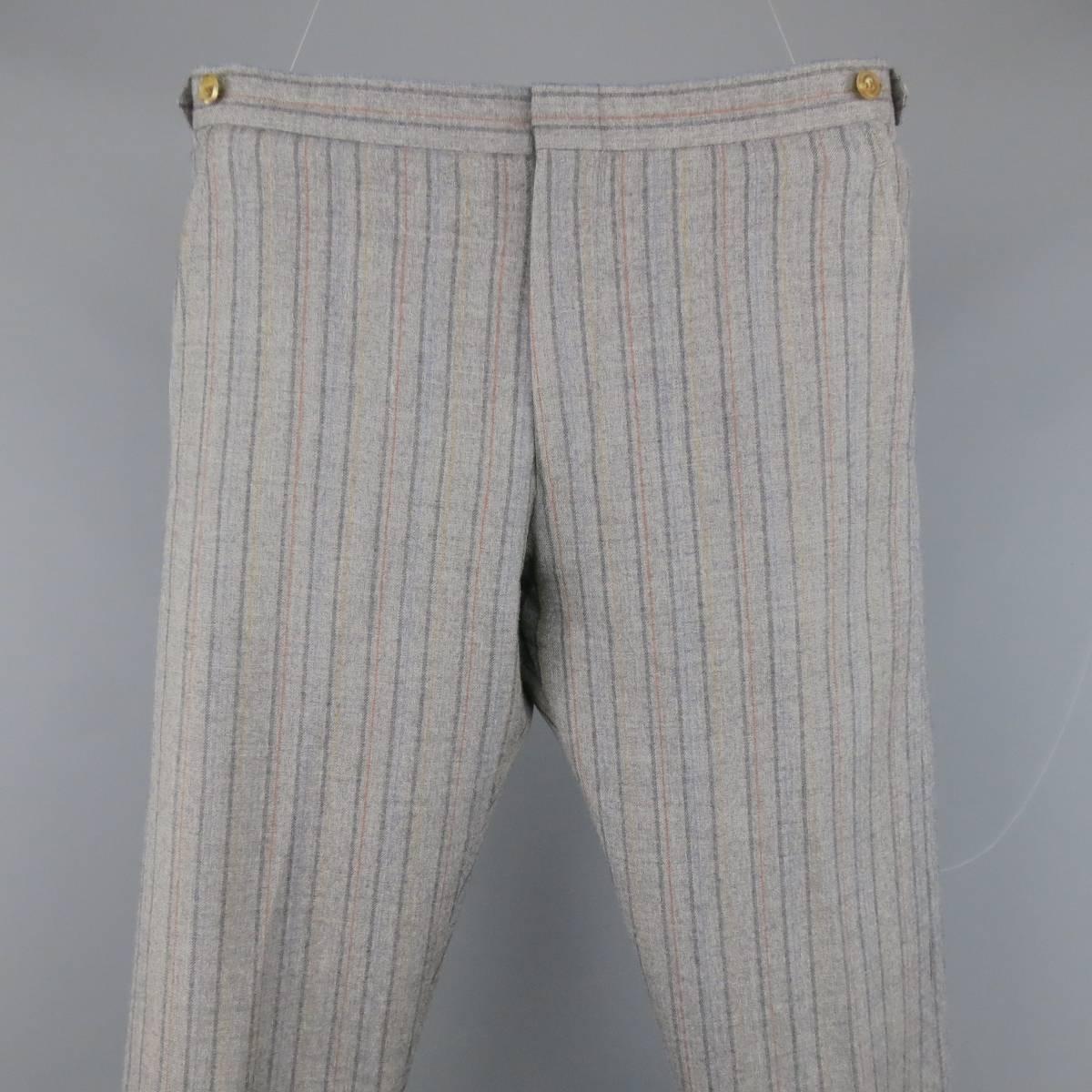 COMME DES GARCONS Causal Pants consists of wool material in a grey color tone. Designed in a zip-fly, clasp closure with inseam side pockets. Detailed in a subtle
multi-color stripe pattern. Relaxed leg and adjustable side tabs. Made in Japan.

