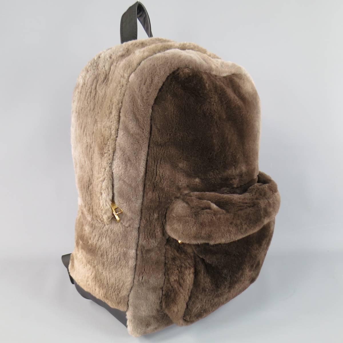 This fabulous and rare MARC JACOBS backpack comes in a multi-tonal taupe brown soft beaver fur and features a double yellow gold tone top zip closure, frontal zip patch pocket, and black leather back panel. Made in USA. Retails at