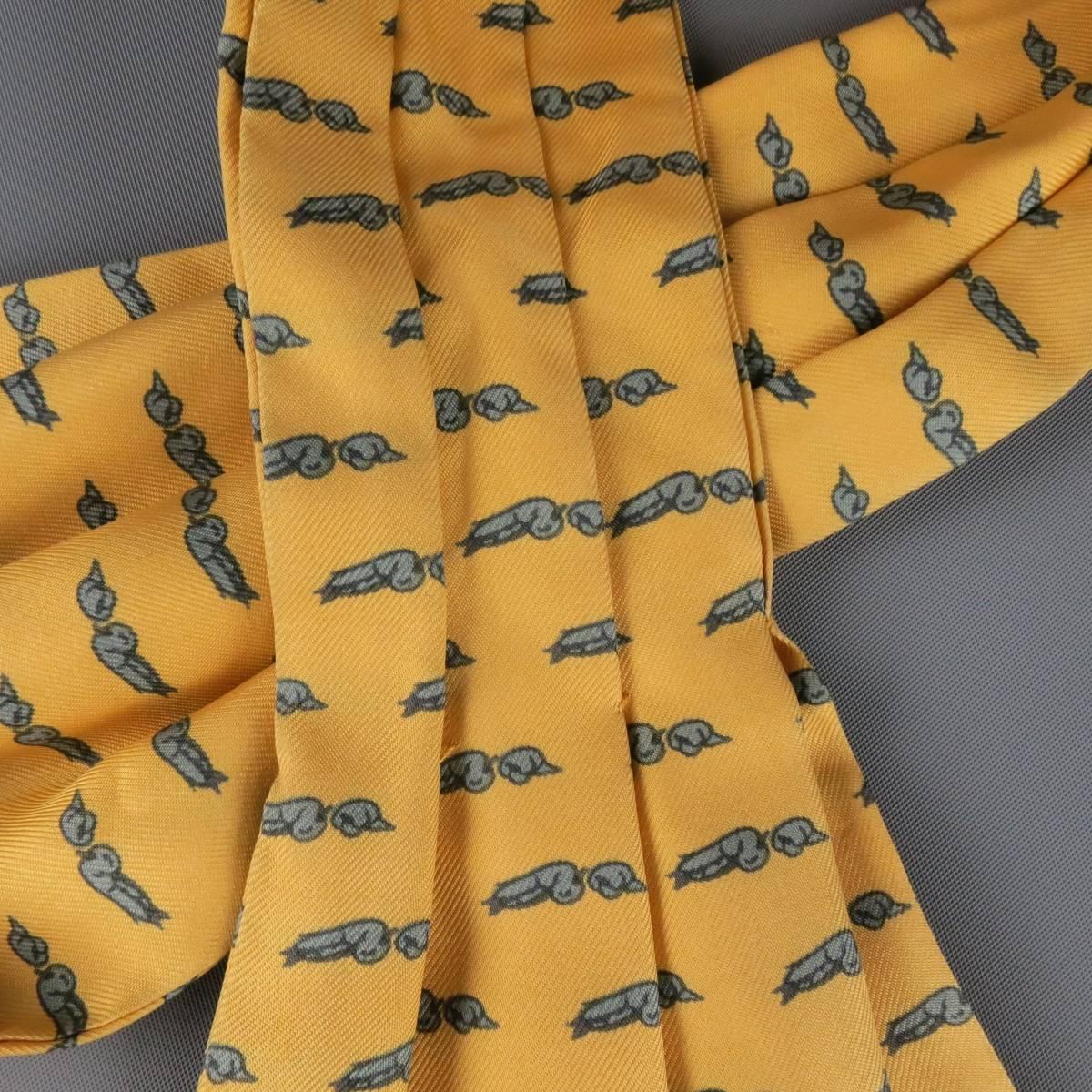 Vintage HERMES gold yellow silk twill ascot features a grey bird print. Made in France.
 
Good Pre-Owned Condition.
 
Measurements:
 
Length: 45.5 in.
Width: 6.65 in.