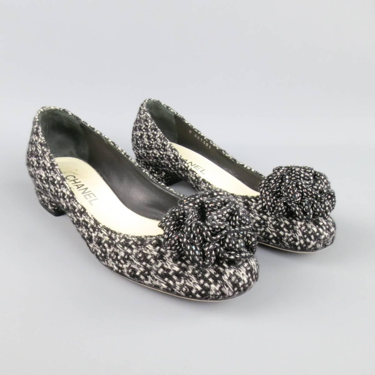 CHANEL black and white tweed ballet flats feature 'Camellia' style flower embellishment and chunky covered heel with silver tone 'CC' logo. Includes original box. Made in Italy.
 
Good Pre-Owned Condition. Retails at $875.00.
Marked: 37 1/2 IT
