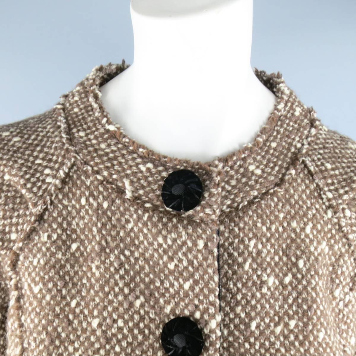 MARC JACOBS  jacket in a light taupe brown cream wool tweed featuring a high crew neck, three quarter sleeves, hidden placket snap closure, black velvet decorative buttons, velvet trimmed pockets, and raw edge details throughout. Made USA. 