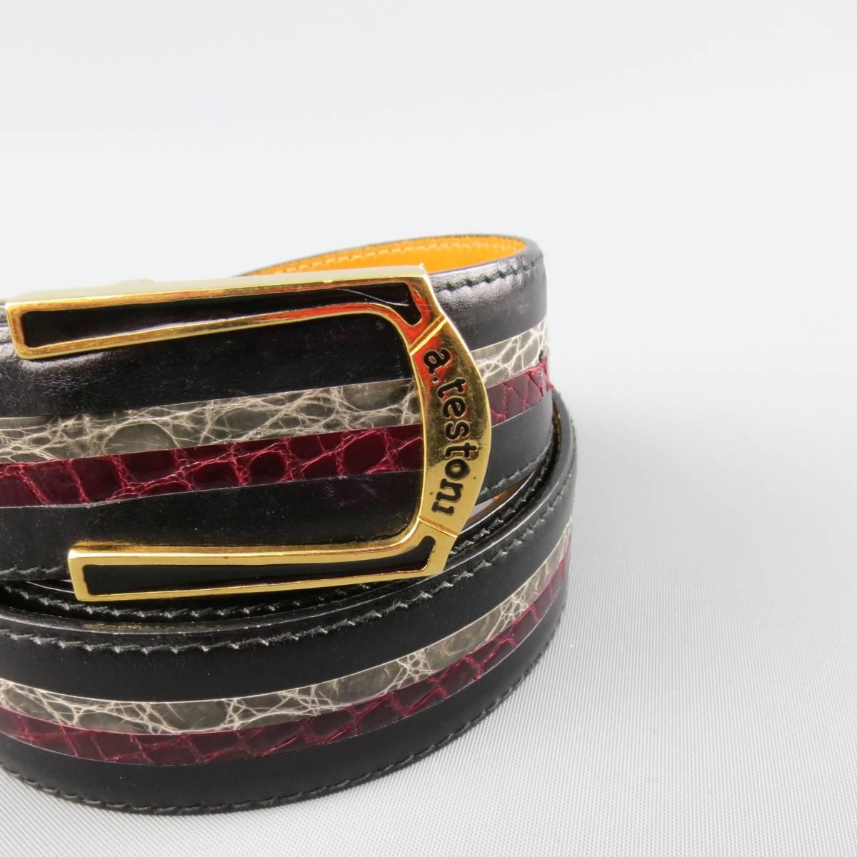 Vintage A. TESTONI dress belt features a smooth black leather strap with burgundy and gray textured stripe and gold tone buckle with black enamel details. Made in Italy.
 
Excellent Pre-Owned Condition.
Marked: 90 / 36
 
Measurements:
 
Length: 42