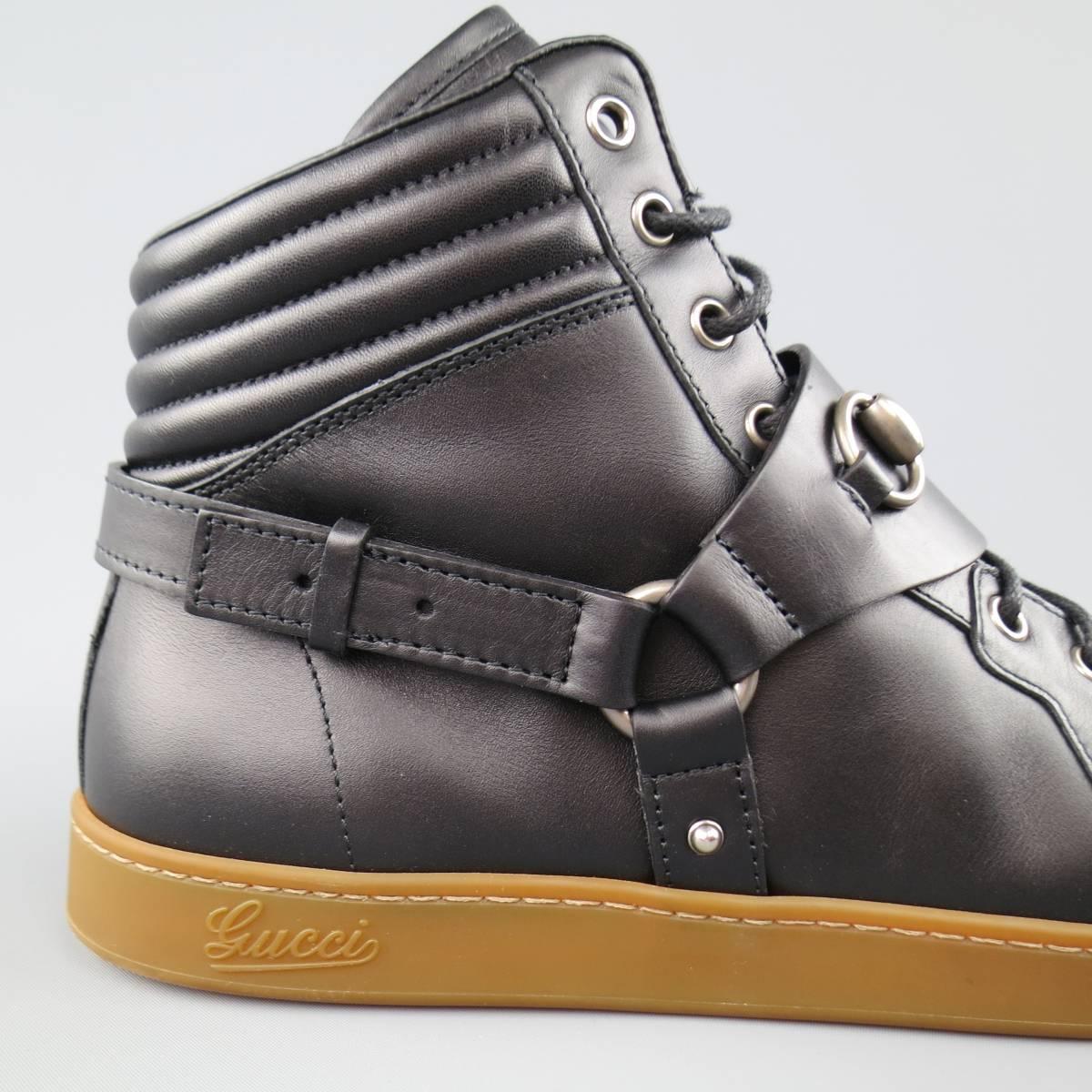 GUCCI HighTop Sneakers consists of leather material in a black color tone. 
Designed with a harness strap, horse-bit in silver tone over black laces. Brown rubber sole. Comes with original box and dust bag. Made in Italy.
 
Excellent Pre-Owned