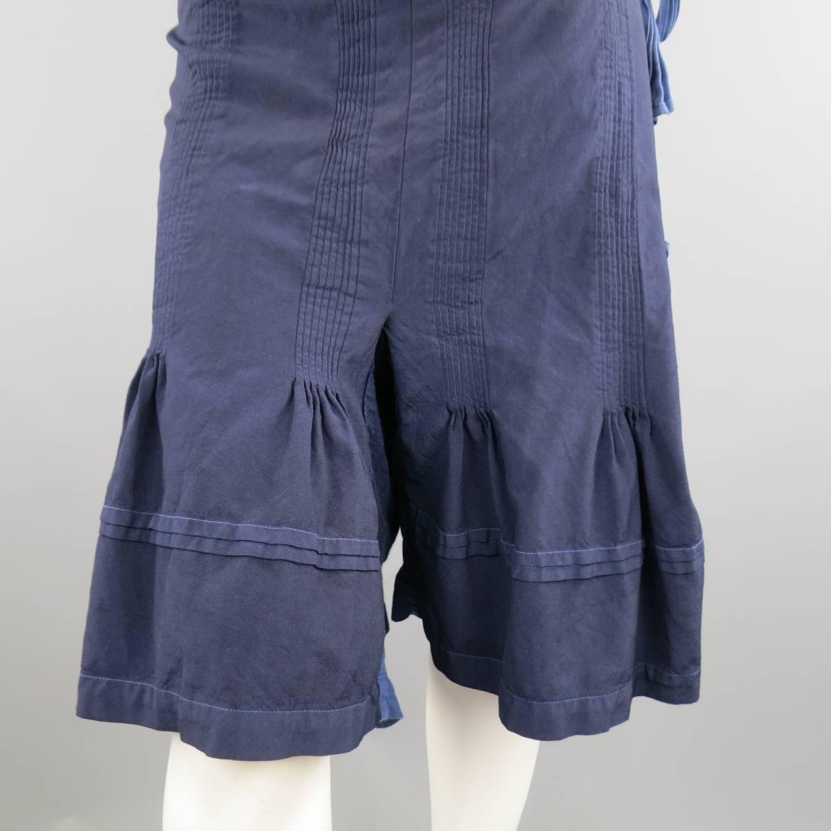 TAO KURIHARA / COMME DES GARCONS navy polyester drop-crotch pants feature a 'thai-style fisherman pant' with adjustable inside button closure, and wrap around tie. Single slit pocket. Gathered ruffle pleating detail throughout. Made in Japan.
 
Good