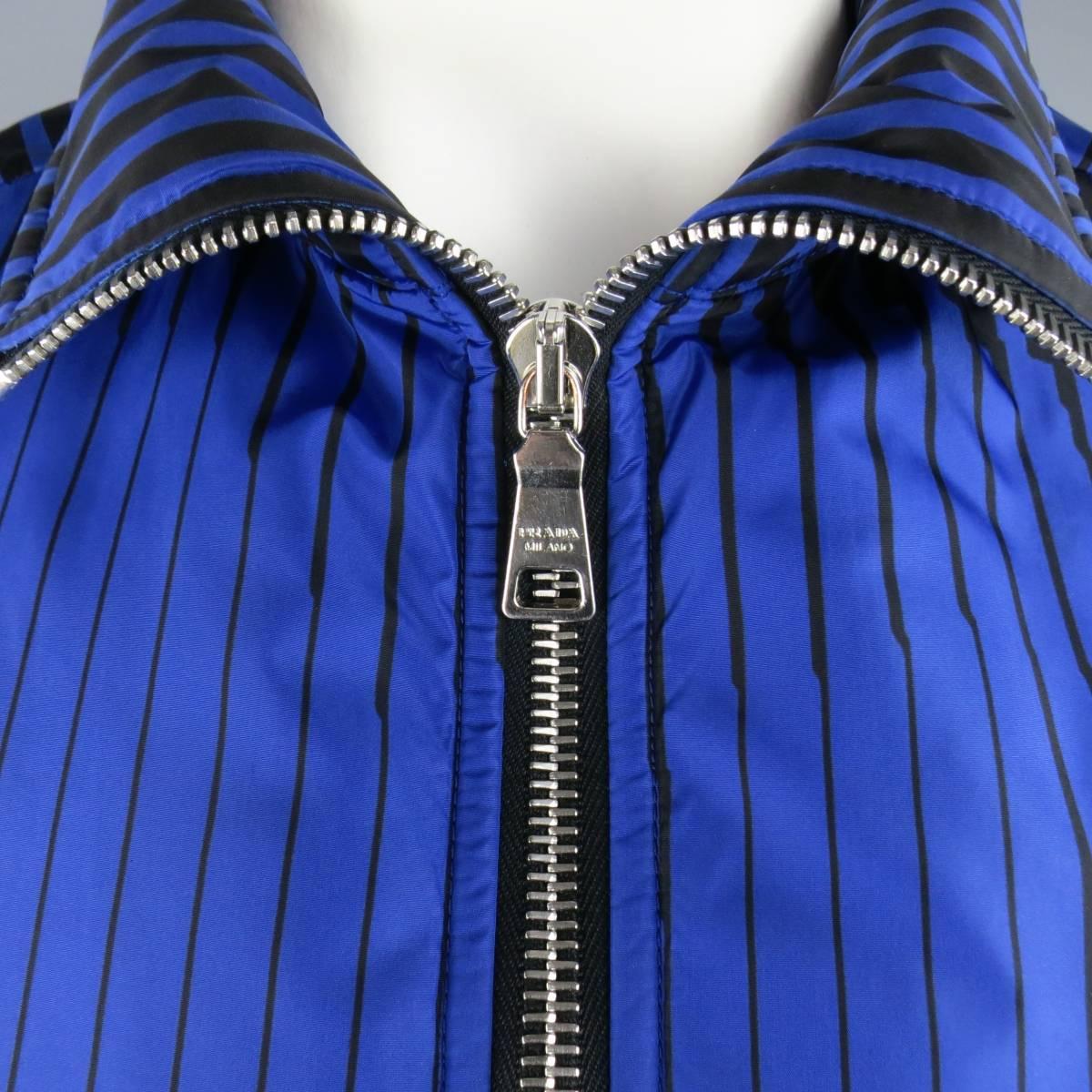 PRADA fall 2008 puffer jacket in an abstract royal blue and black striped nylon featuring a high collar, thick silver tone zip closure, hidden placket zip pockets, and ribbed side panels. Made in Italy.
 
Excellent Pre-Owned Condition.
Marked: IT