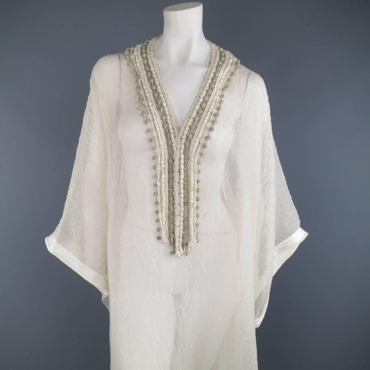 Gorgeous OSCAR DE LA RENTA kaftan style gown in a sheer, lace textured silk and features a v neckline with various embellished fringe trims. Faint discoloration at neckline. As-Is.
 
Good Pre-Owned Condition.
One Size.
 
Measurements:
 
Width: 53